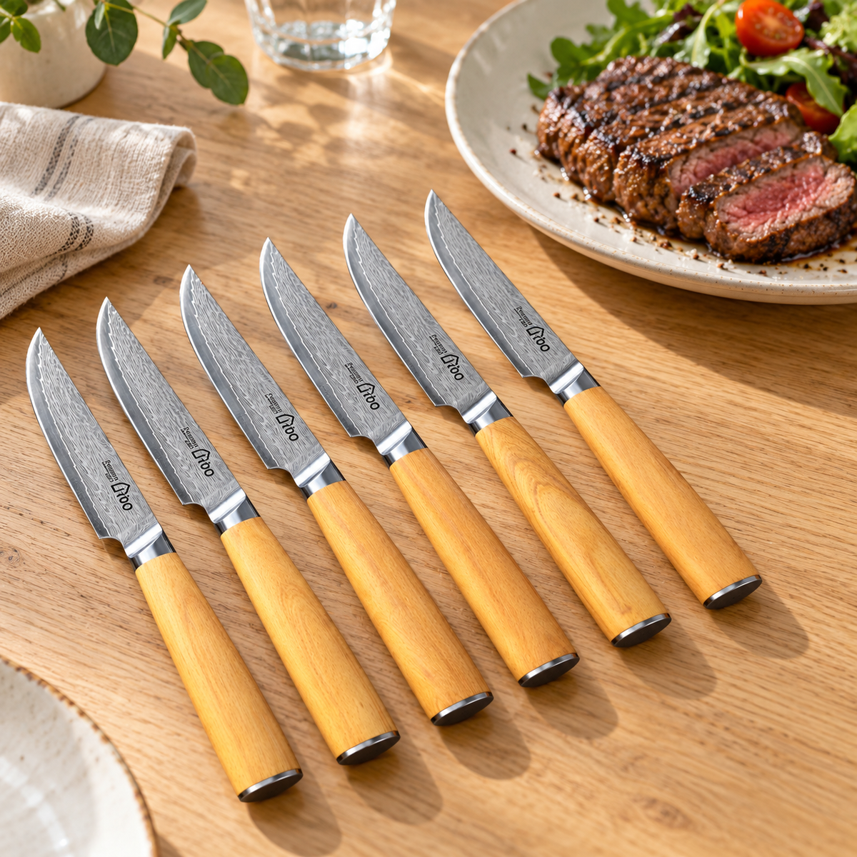 Six i-DOO Damascus steak knives with olive wood handles styled for a shared dinner. Food and tableware are not included.